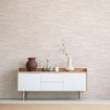 Front view of burlap artworks on a light gray wall above a woode